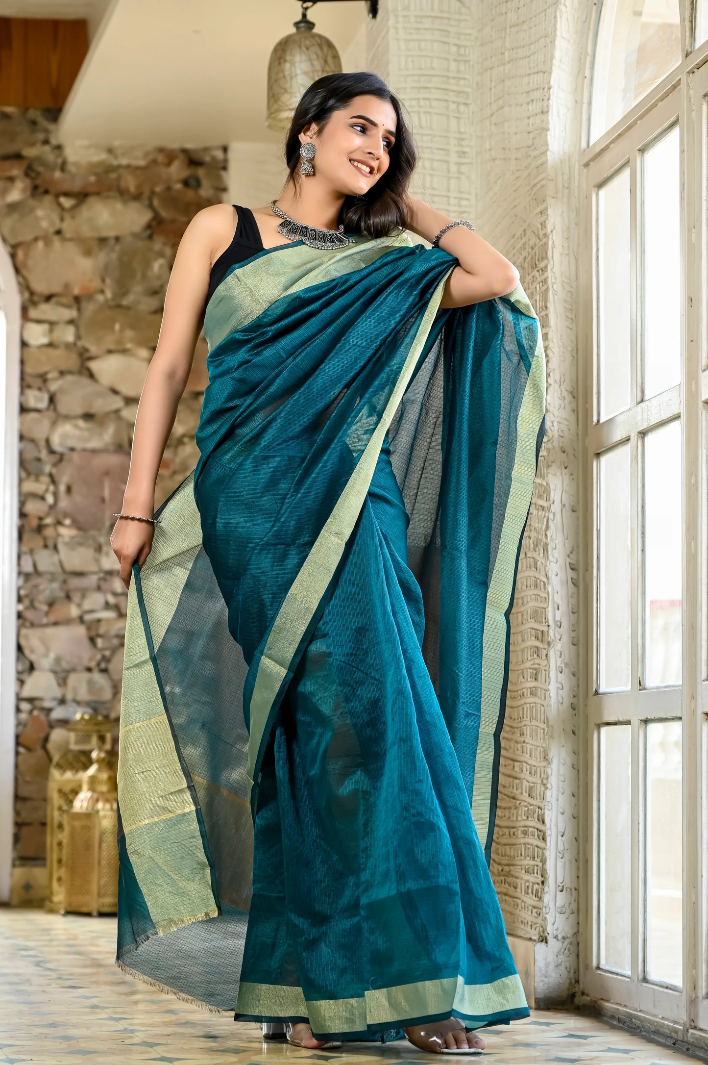 Teal green color kota silk saree with heavy zari border
